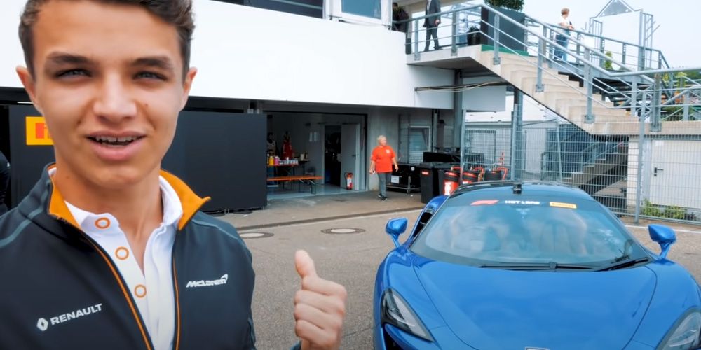 Lando Norris poses next to a McLaren 570S