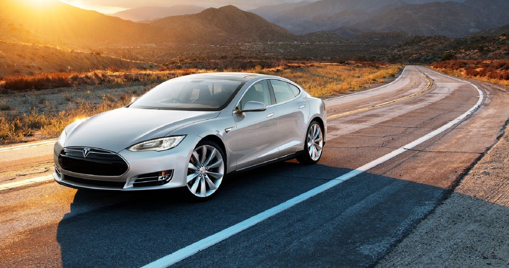 Tesla Model S racing on road at sunset