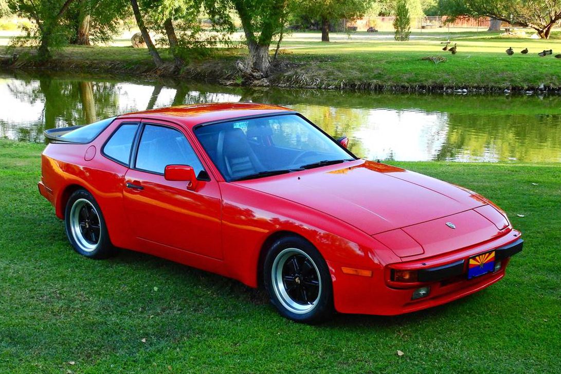 Red 1983 Porsche 944 parked on grass