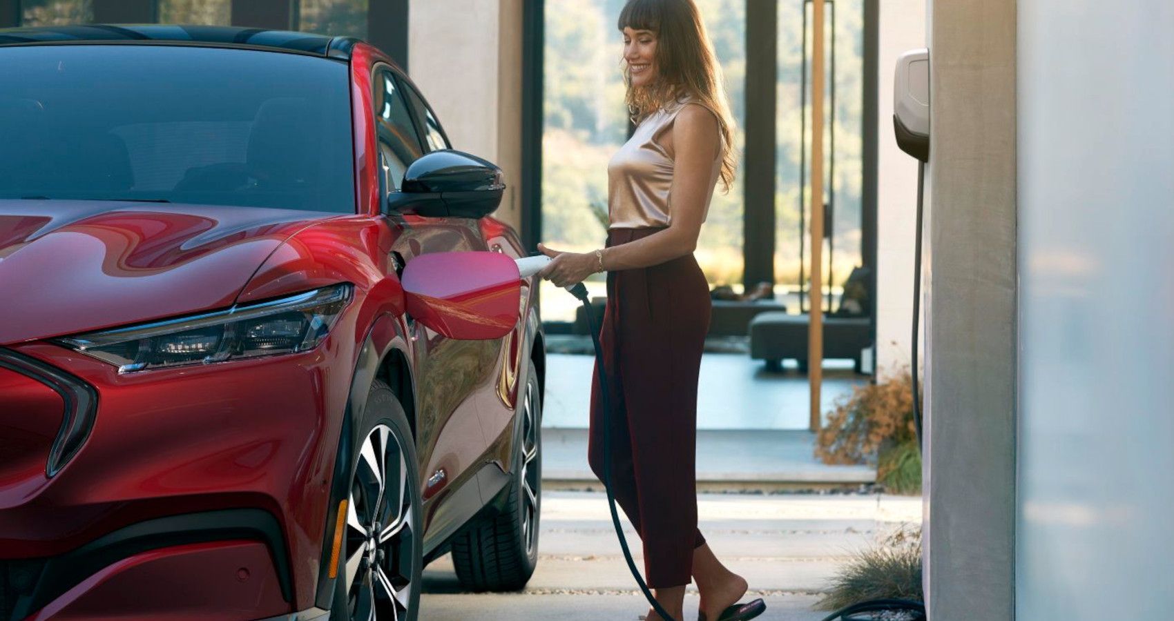 woman charging red electric vehicle