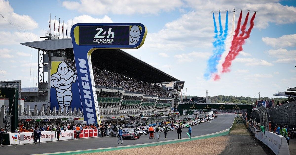 24h Le Mans Race Track Crowd Stand, view from distance, planes in sky, cars on track