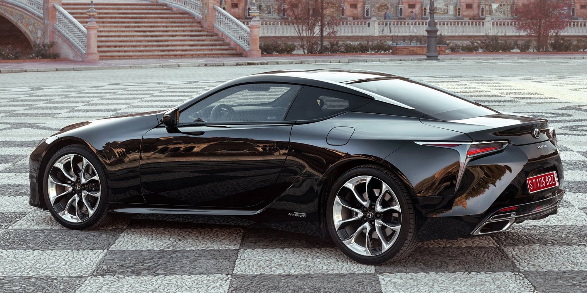 Rear 3/4 view of a black LC500h on a town square
