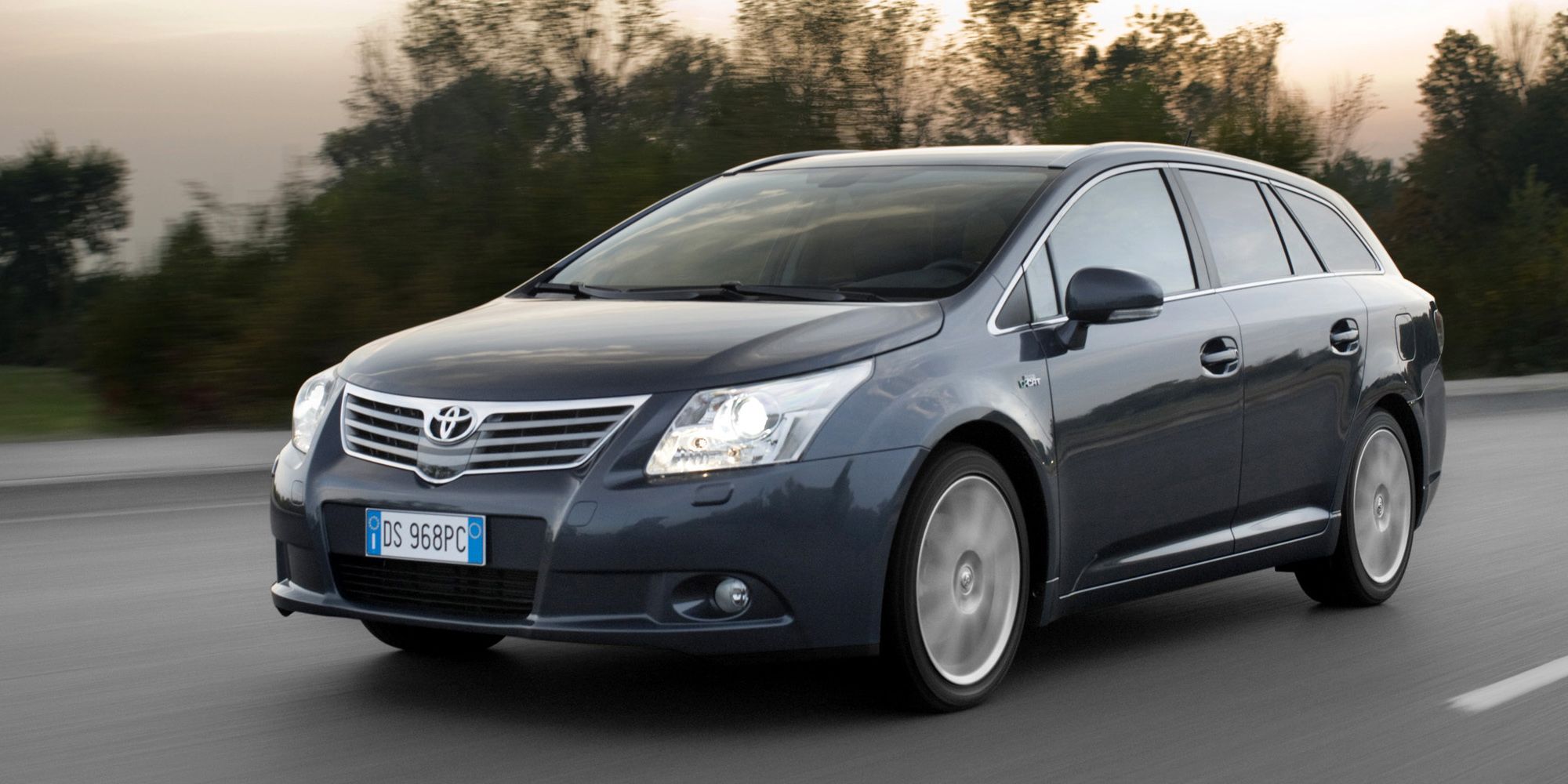 Front 3/4 view of a dark blue Avensis Wagon on the move