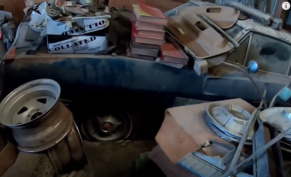 A 1970 Dodge Charger underneath piles of parts and books