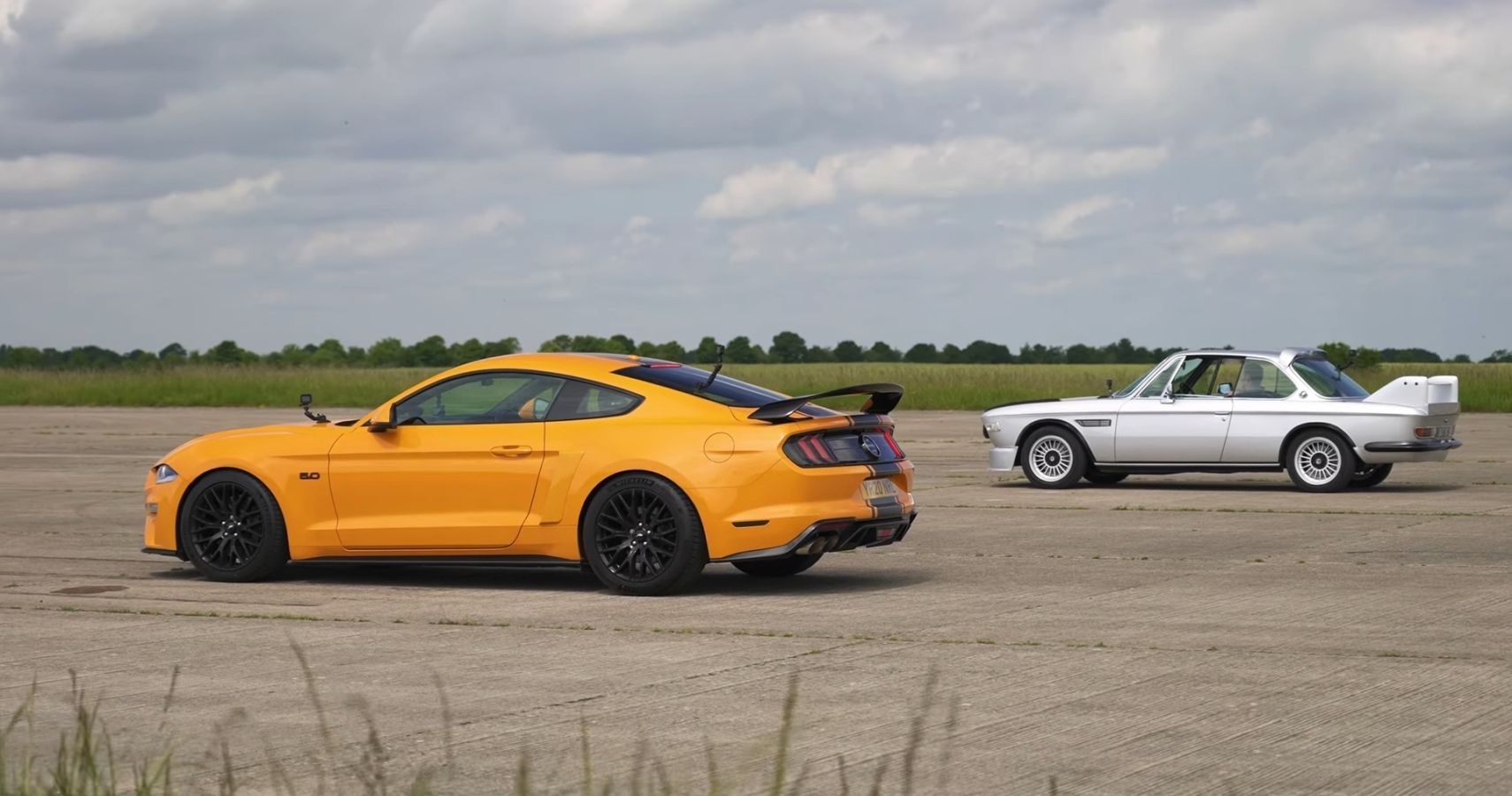 Yellow Ford Mustang vs Silver Electric BMW 3.0 CSL Featured Image