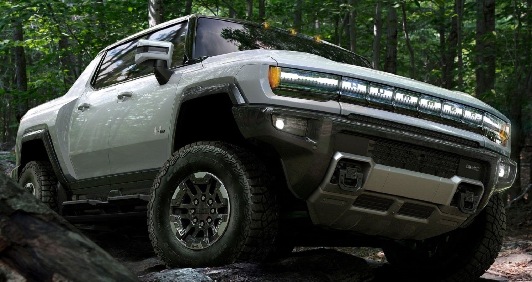 GMC Hummer, white, off road in forest, front quarter view closeup from below