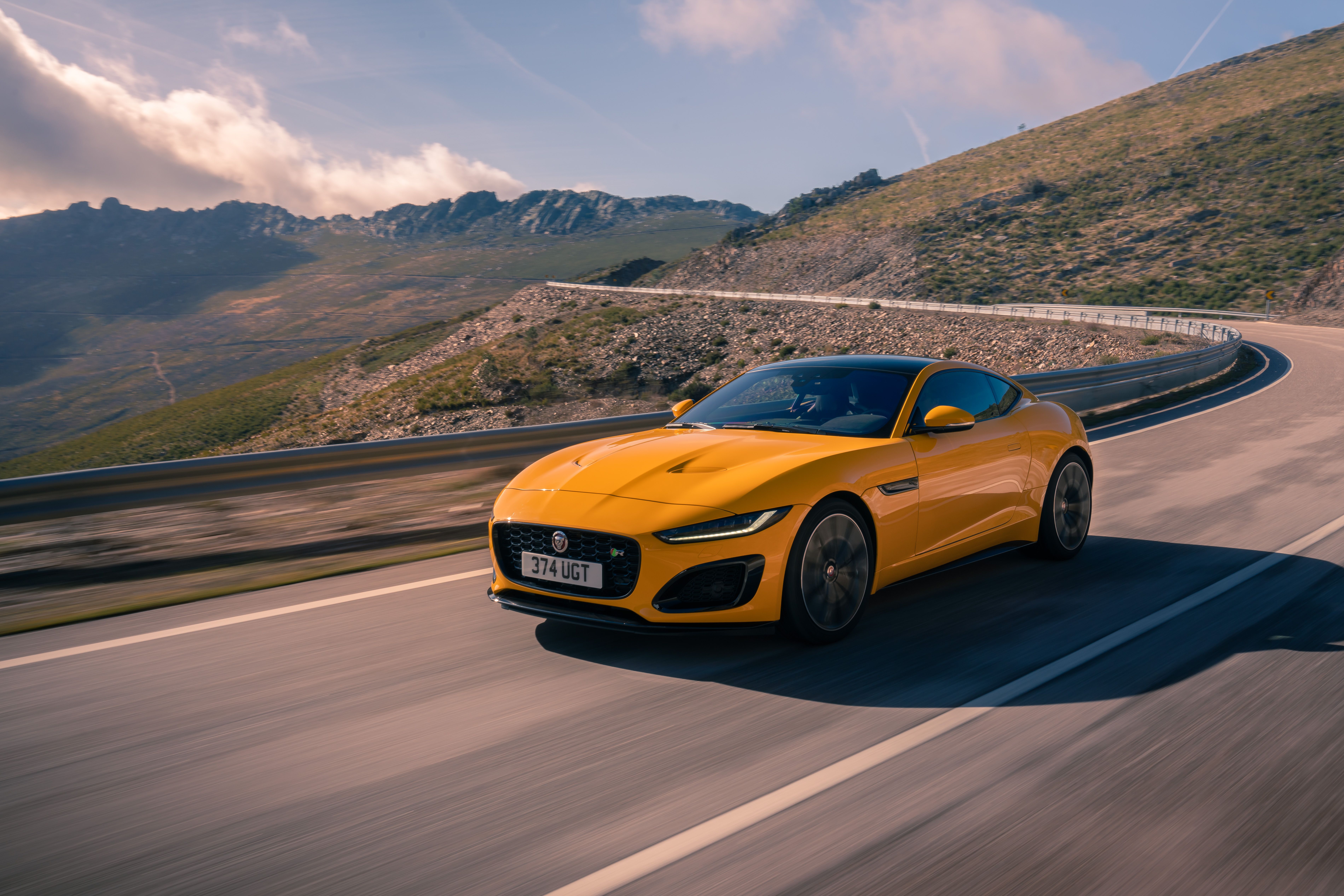 The Jaguar F-Type Coupe Sorrento yellow on the road. 