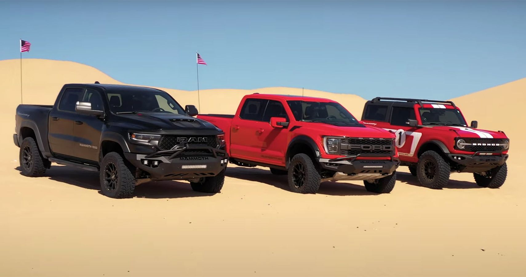 Hennessey: Ram TRX Ford Raptor Ford Bronco on sand dunes, front view of all in a line