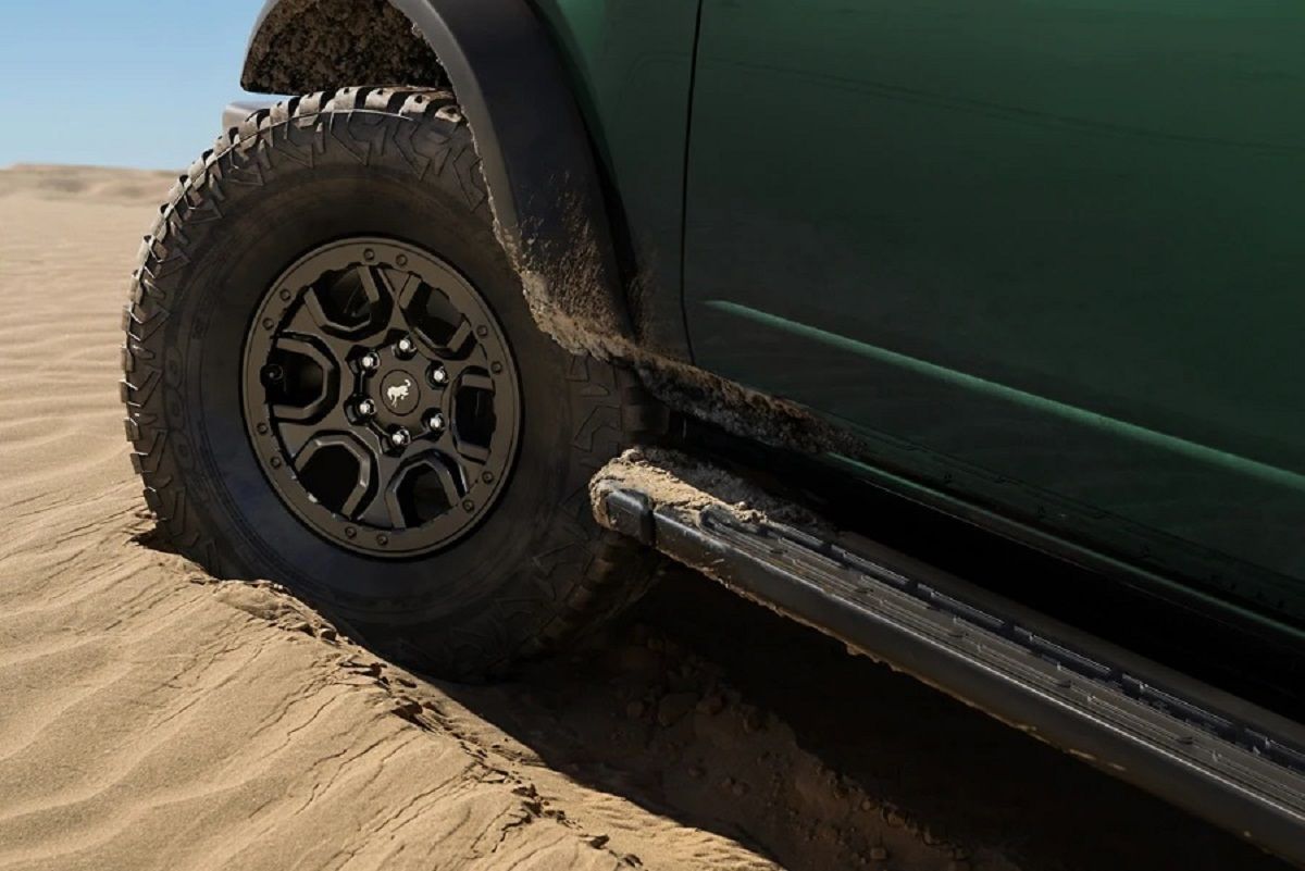 2022 Ford Bronco 4 door, green, side close up view of front wheel, in desert