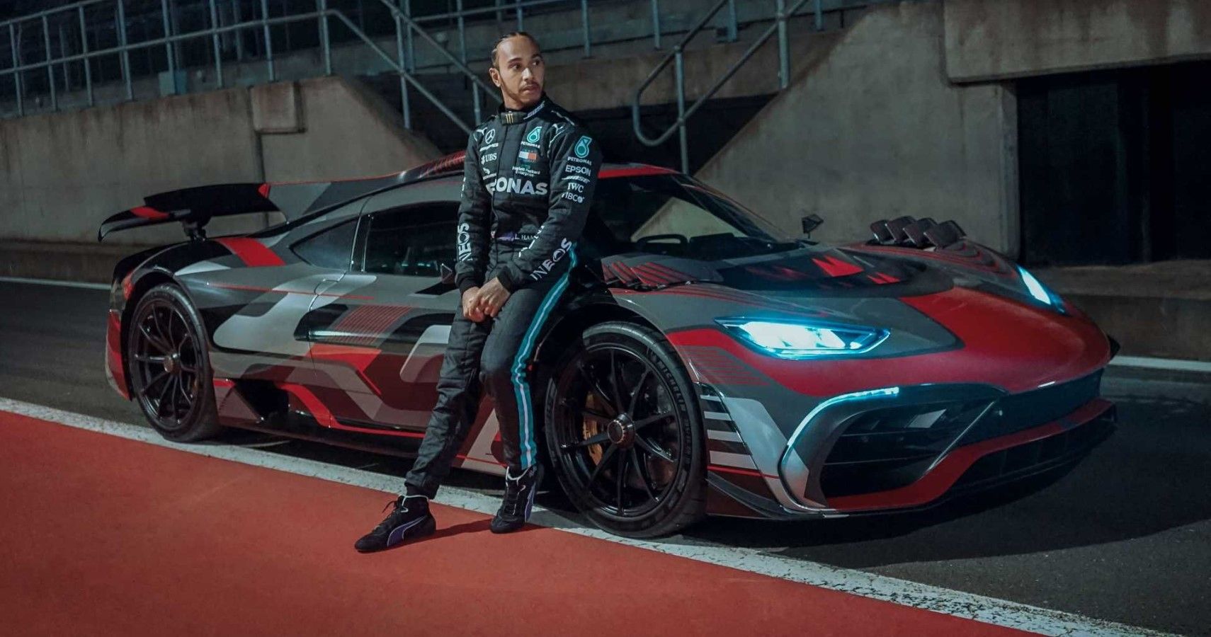 Lewis Hamilton posing next to his Mercedes AMG One