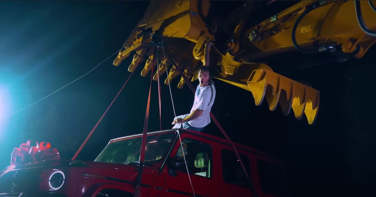 WhistlinDiesel YouTube Channel Mercedes G Wagon hanging from excavator with Cody in sunroof