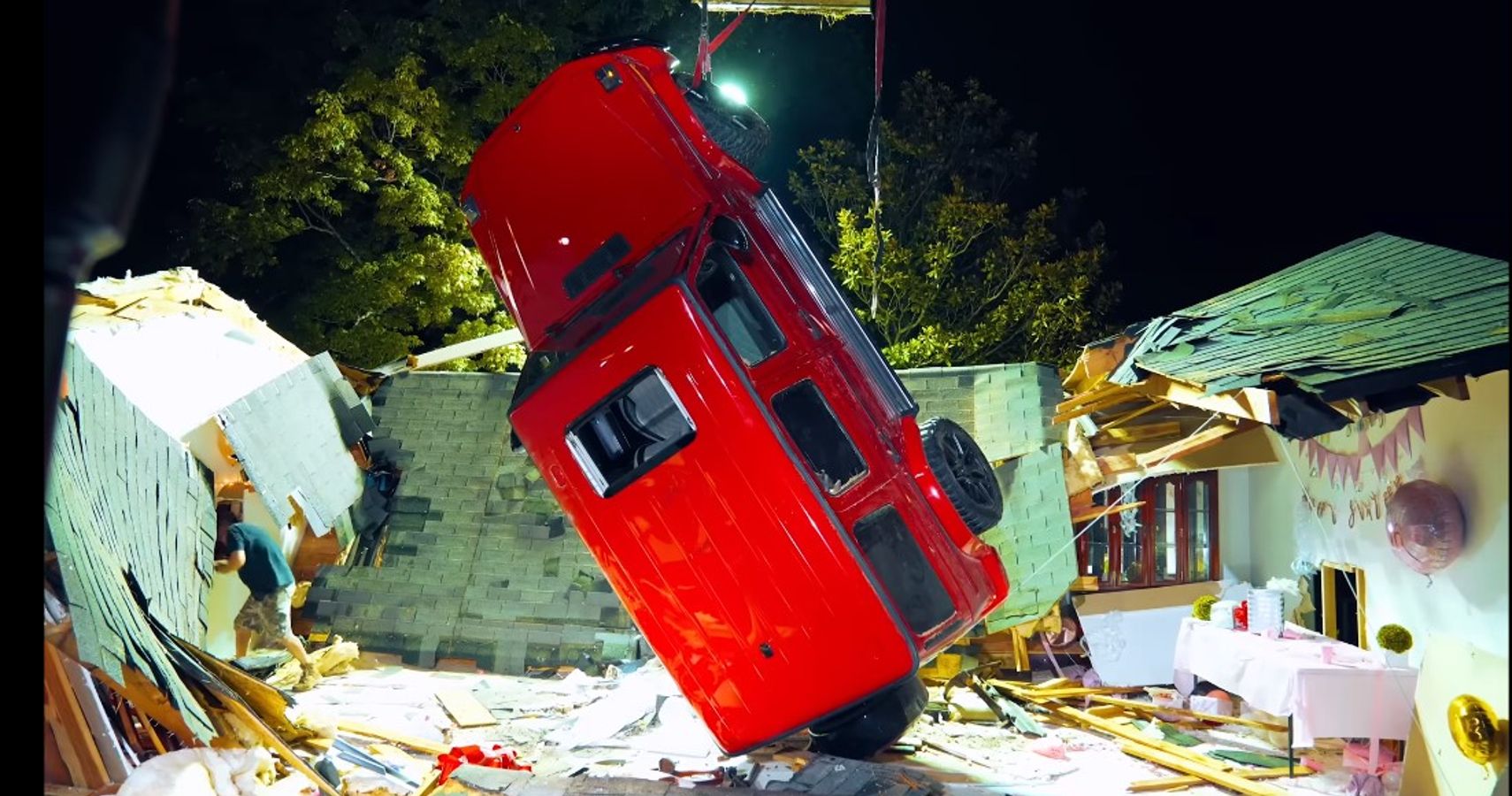 Mercedes G Wagon hanging from one strap after falling through roof