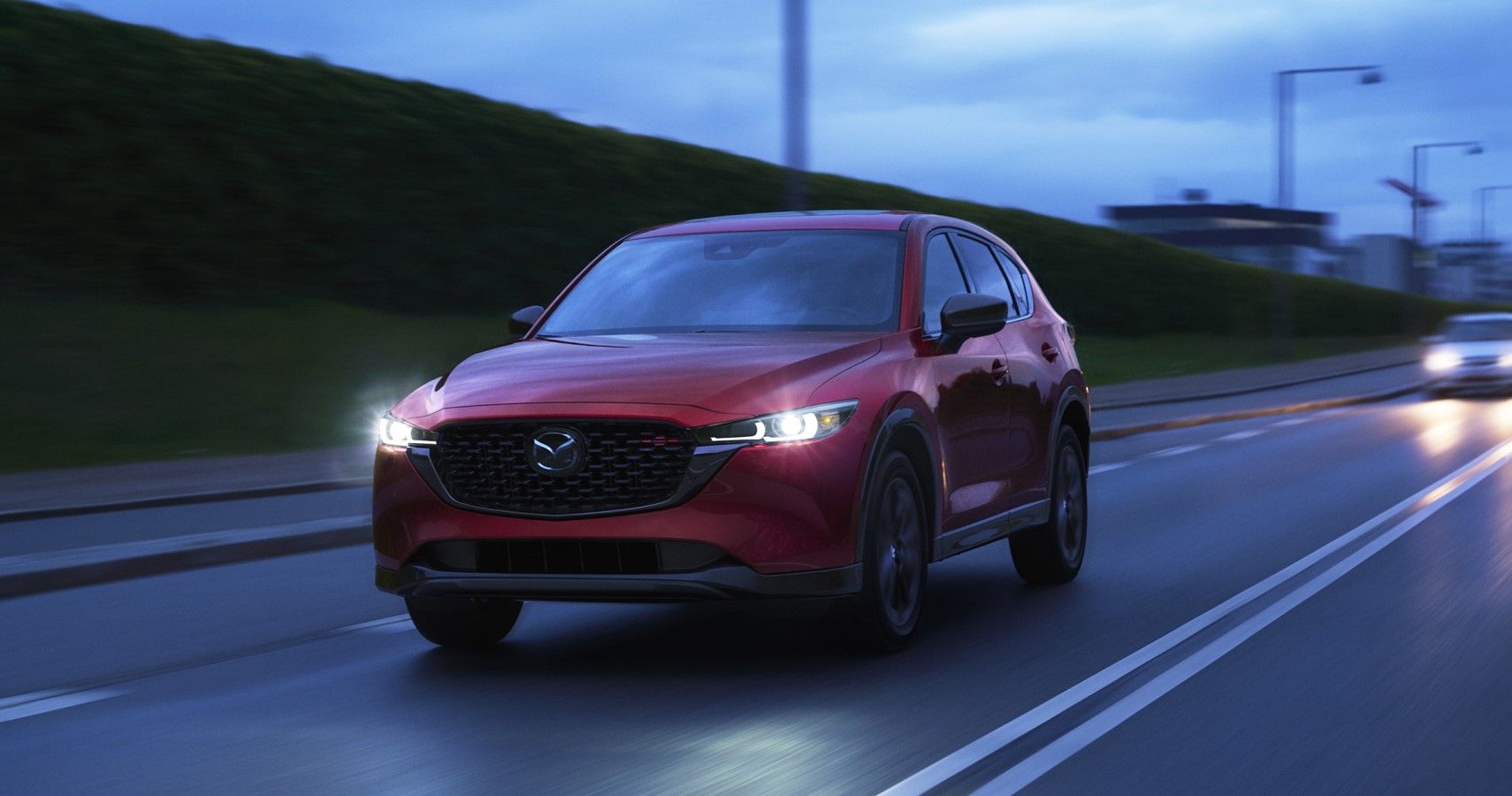 2023 Mazda CX-5 cruising on the highway front third quarter view