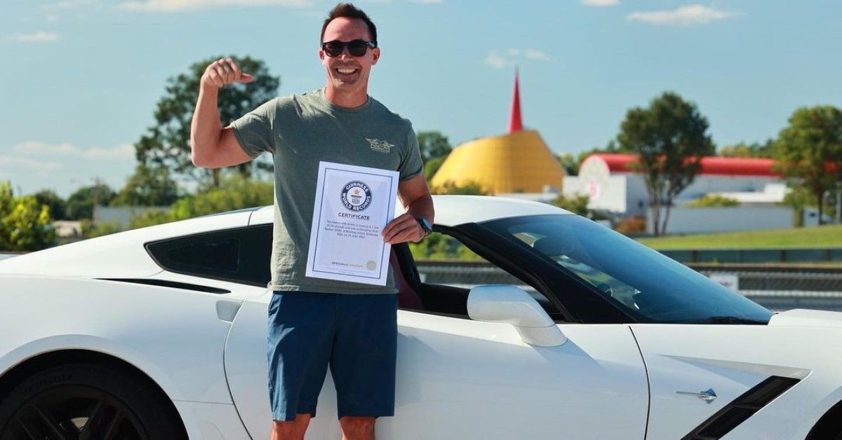 Scot showing off his C7 Corvette as he poses with his Guinness World Record certificate 