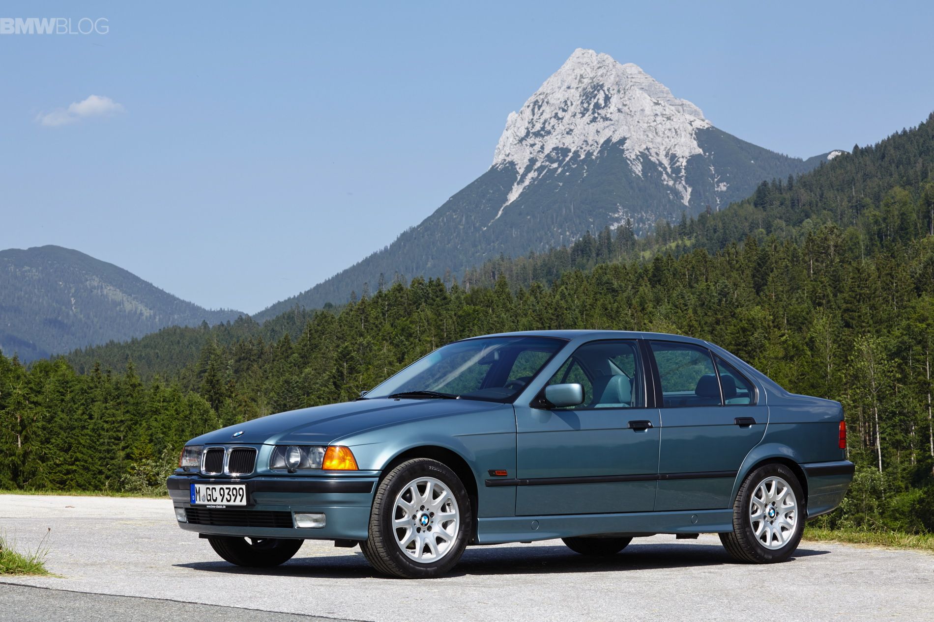 Blue 1998 BMW 3-series E36 with mountains in the background