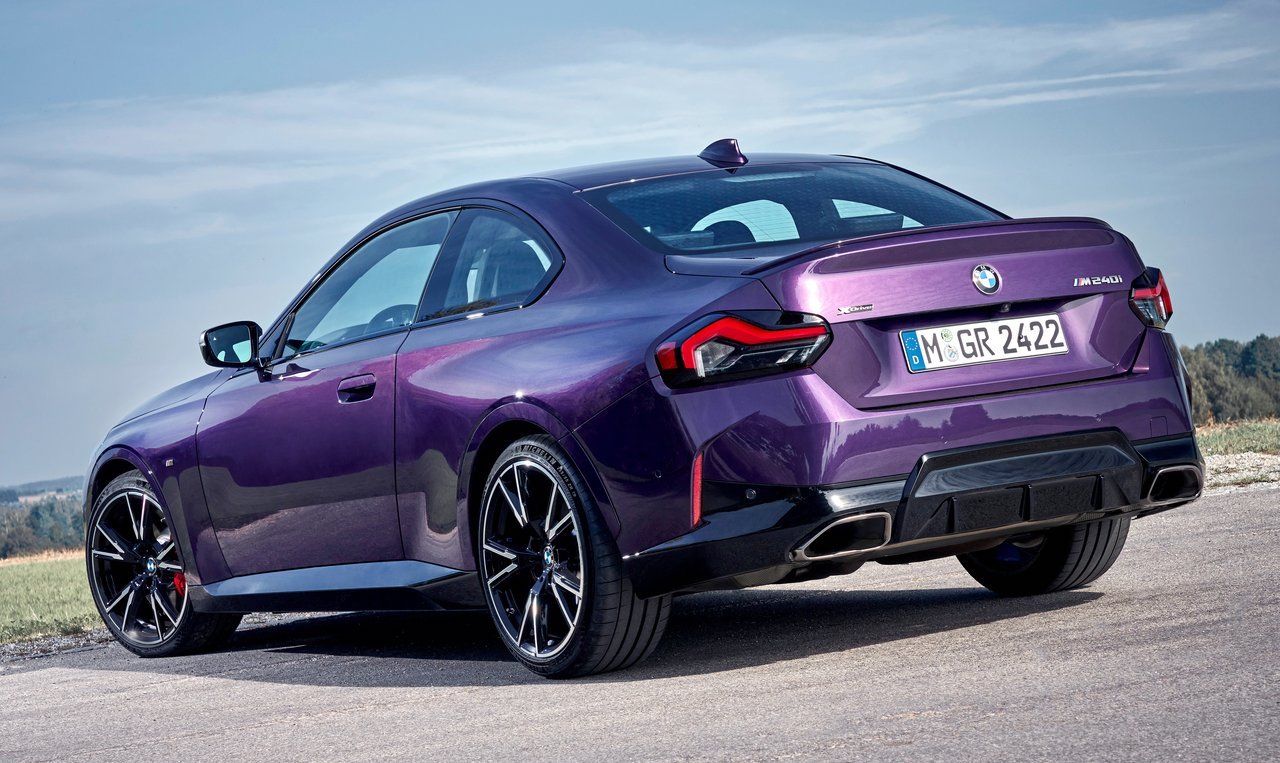 A purple BMW M2 from the back left side