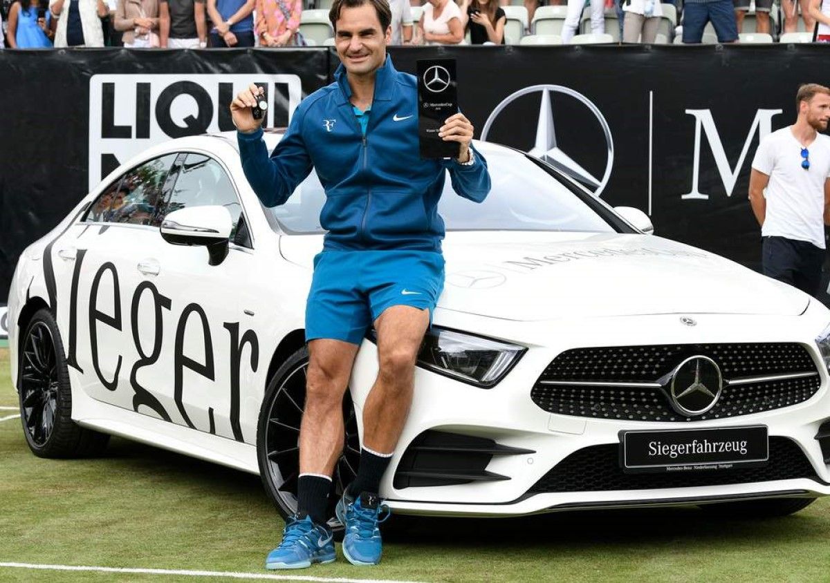 Roger Federer Poses next to a Mercedes-Benz CLS 450 in white after winning the Mercedes tennis cup 