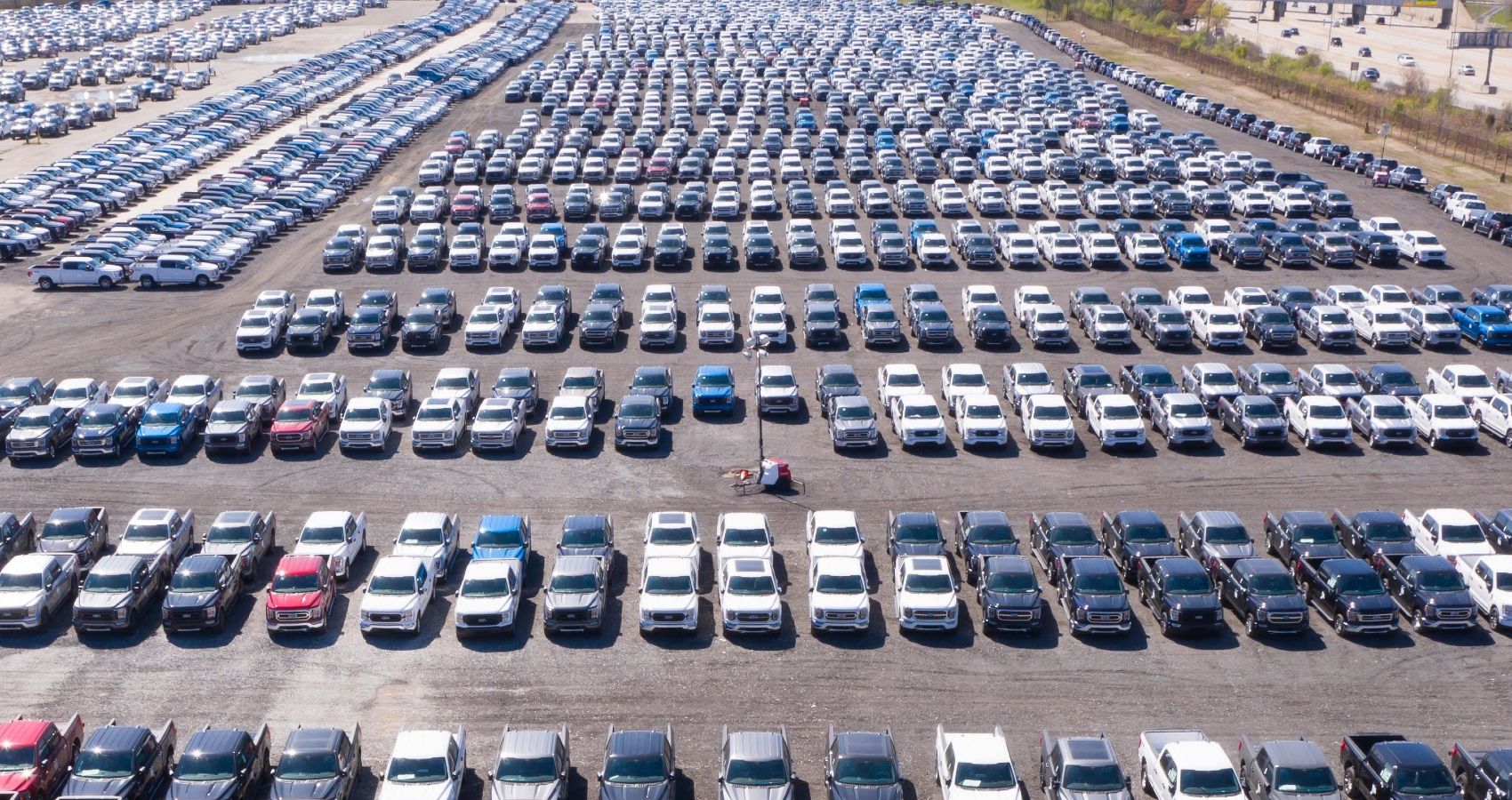 F-150 chip shortage economy parking lot full ford trucks effect rows-2