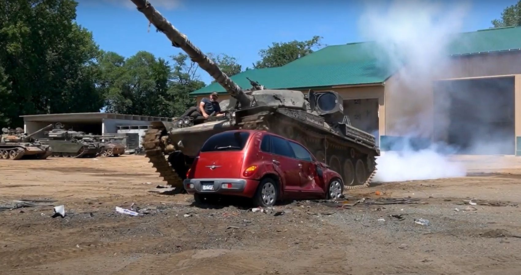 Herman Tank running over PT Cruiser, red car and tank, smoke