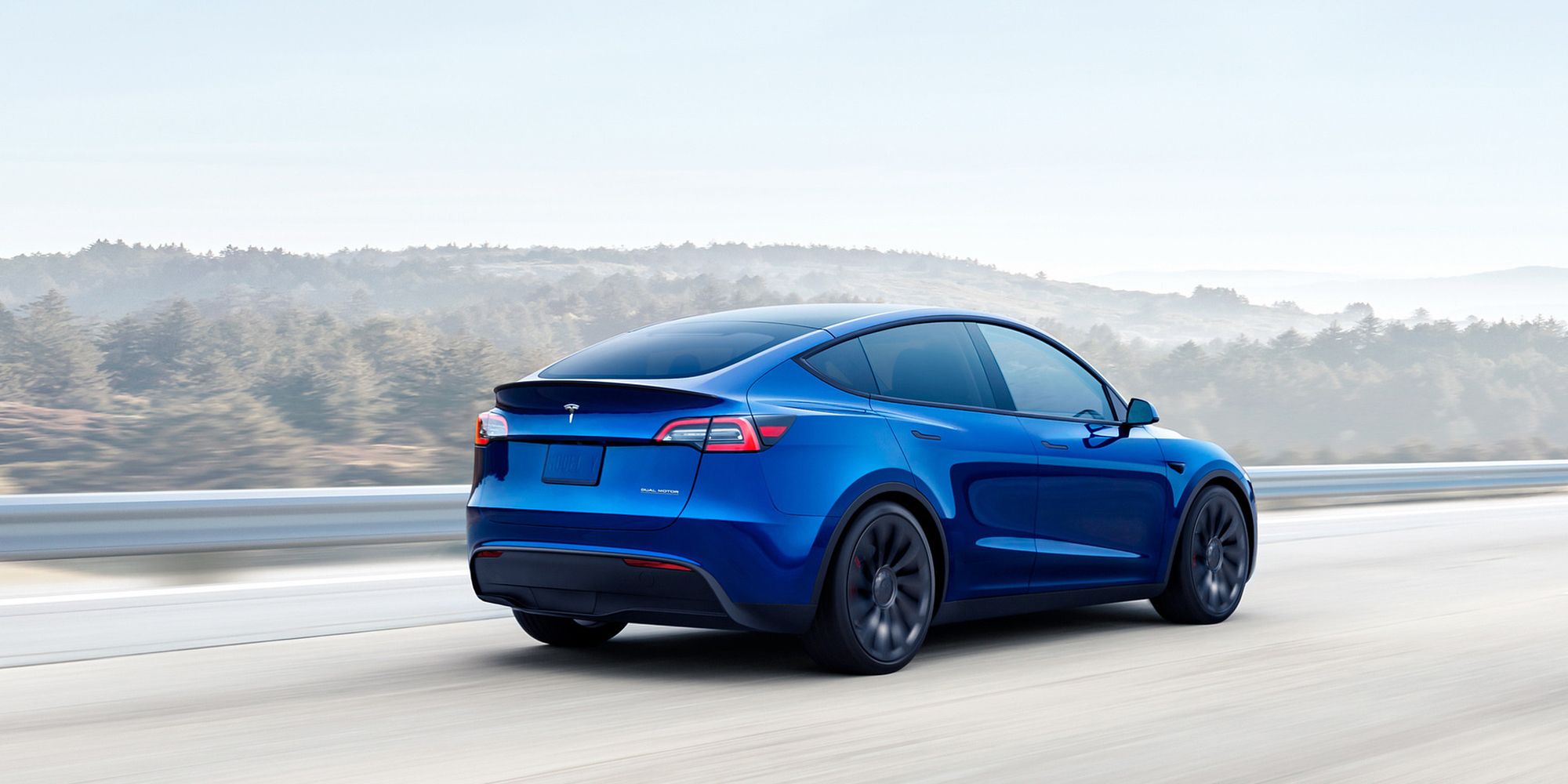 Tesla Model Y Rear Quarter Blue Driving
