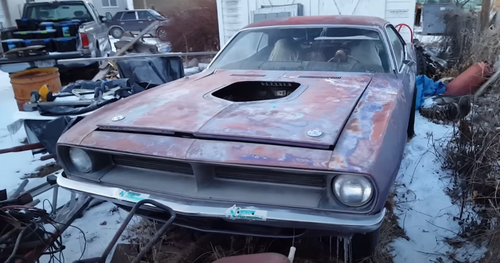 A 1970 Plymouth Cuda sitting in a snow-covered driveway