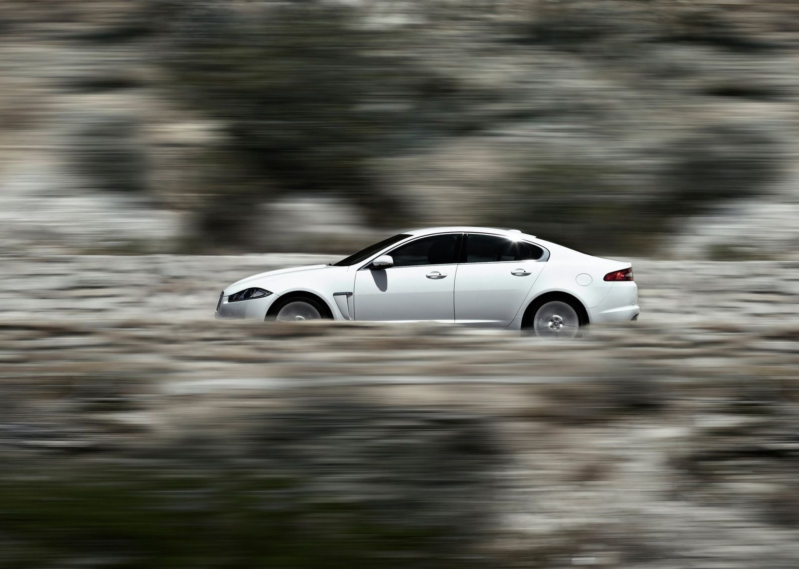 2012 Jaguar XF White Accelerating Side Profile