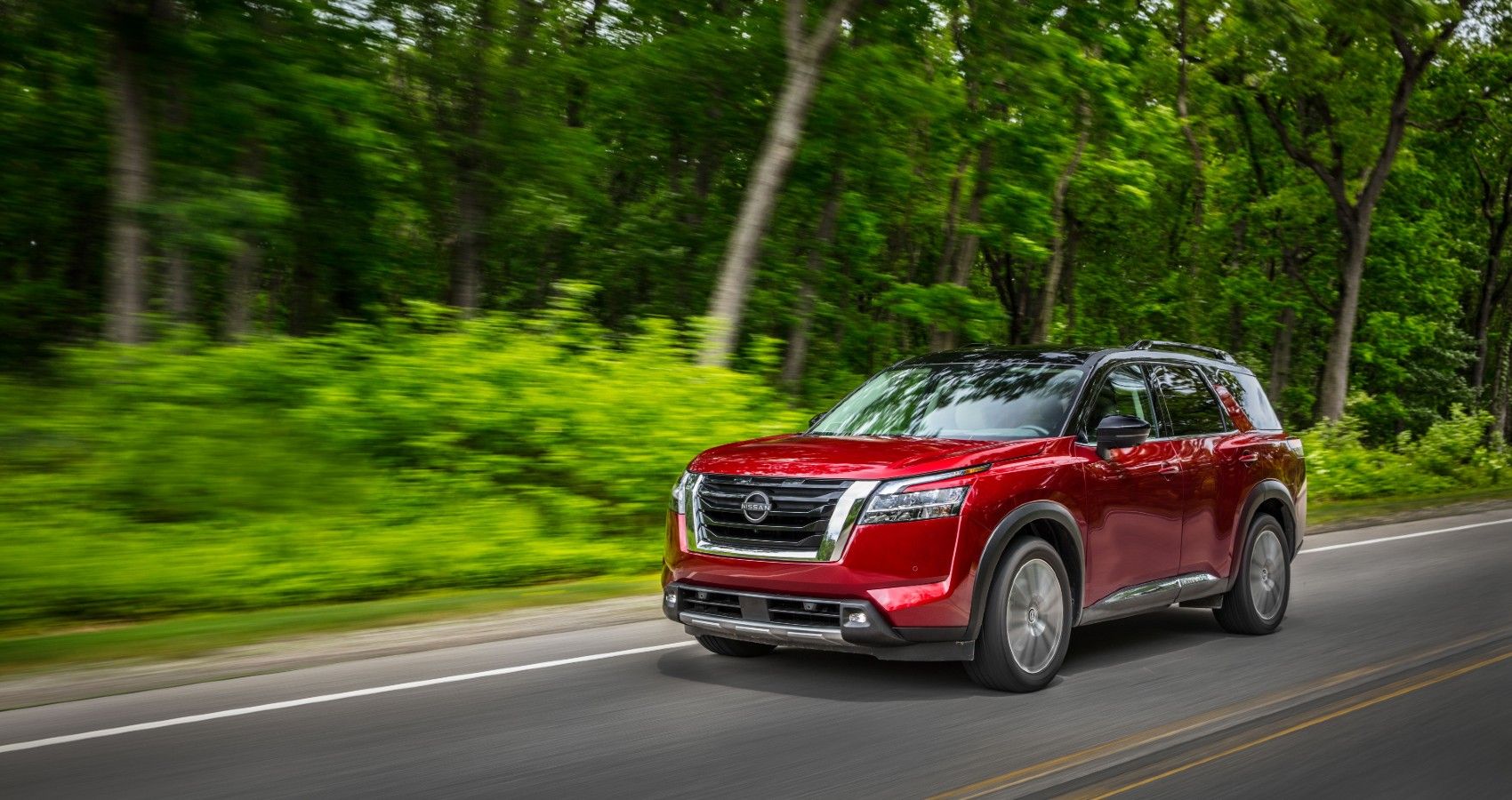 Front 3/4 view of a red 2022 Nissan Pathfinder on the road