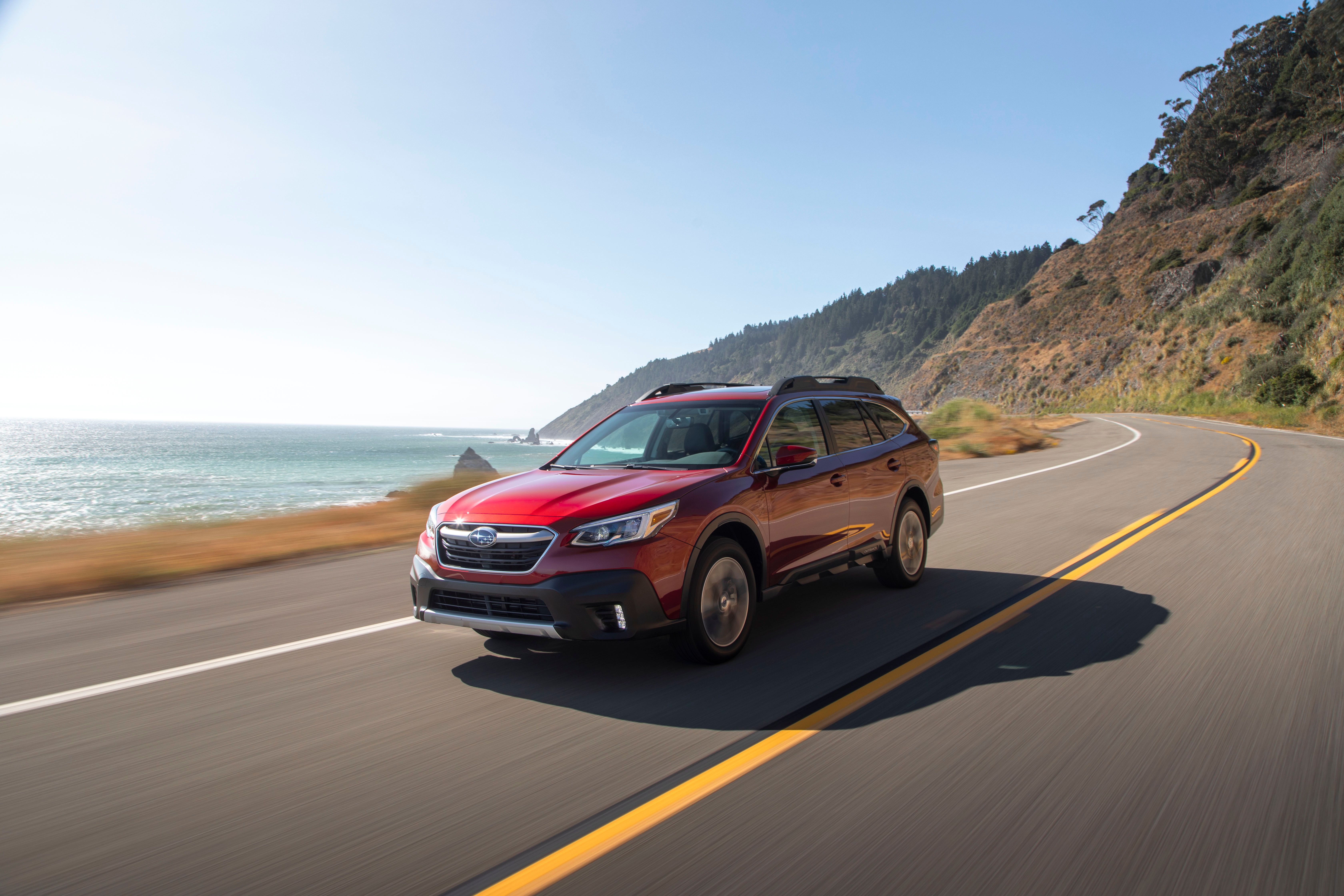 Red 2022 Subaru Outback speeds up on the road