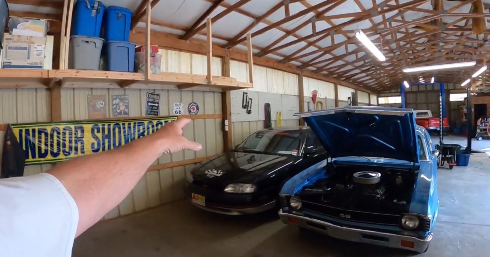 Chevy Monte Carlo in barn with other cars around, blue, front