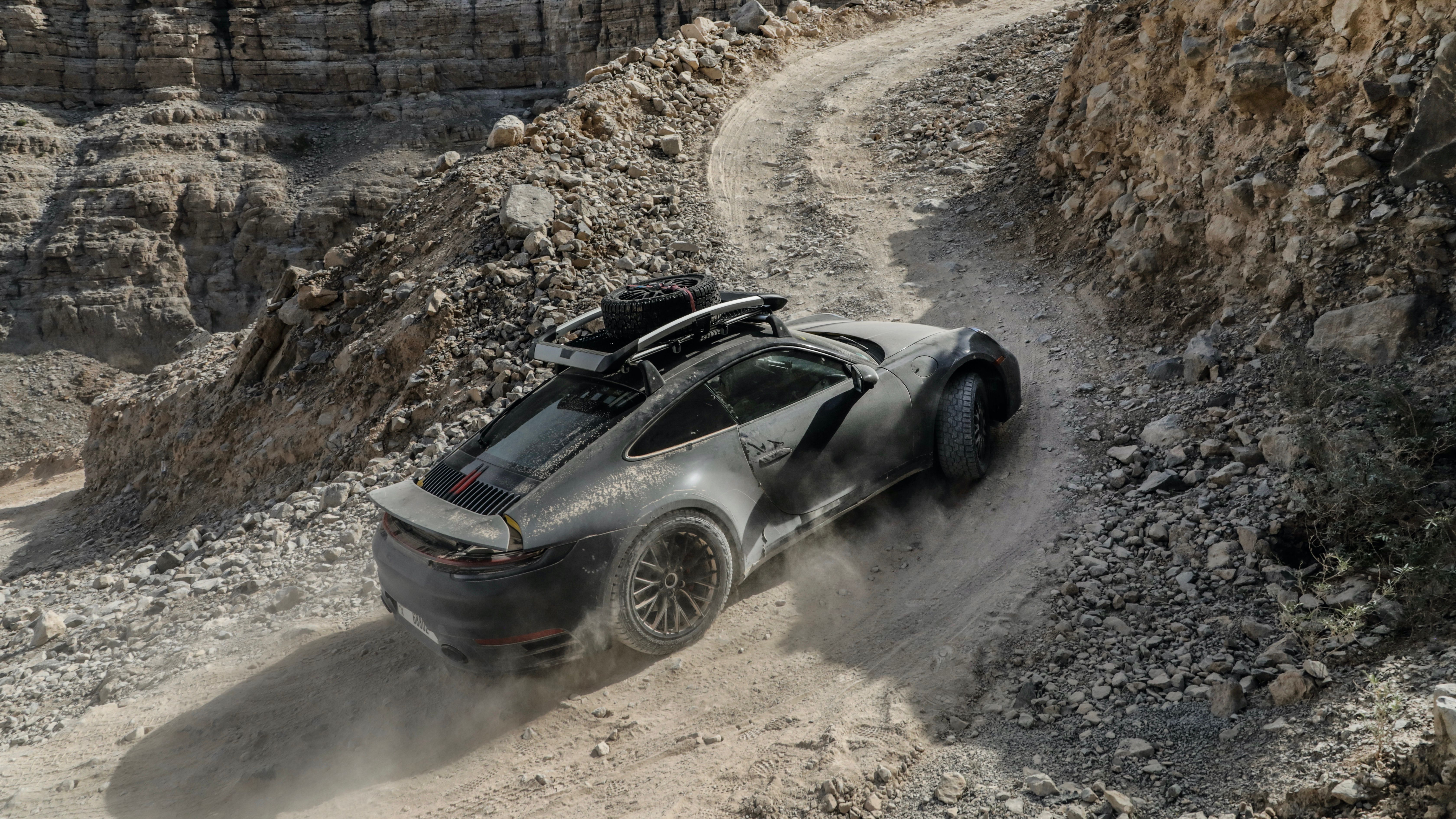 Black 2023 Porsche 911 Dakar Driving Up Rocky Terrain
