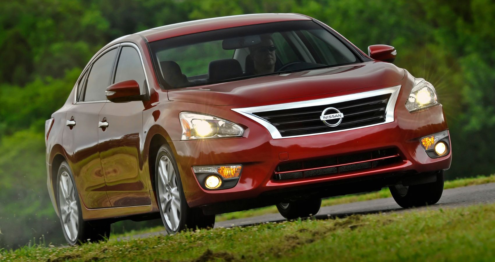 Red 2014 Nissan Altima on the road