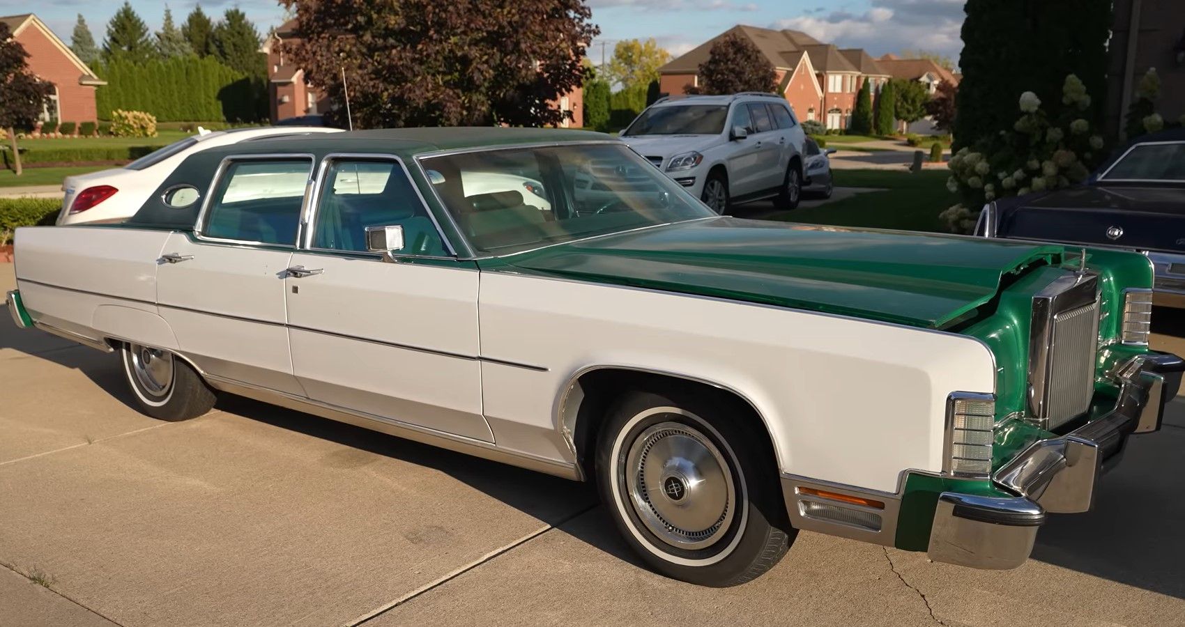 parked green white 1970s Lincoln Continental driveway