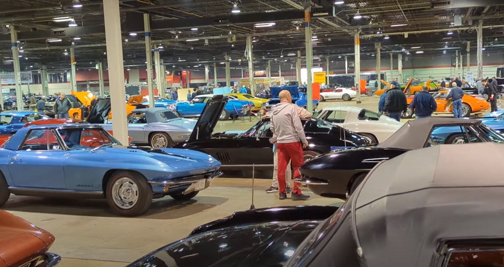 Multiple cars in hangar, muscle cars and Corvette Nationals show