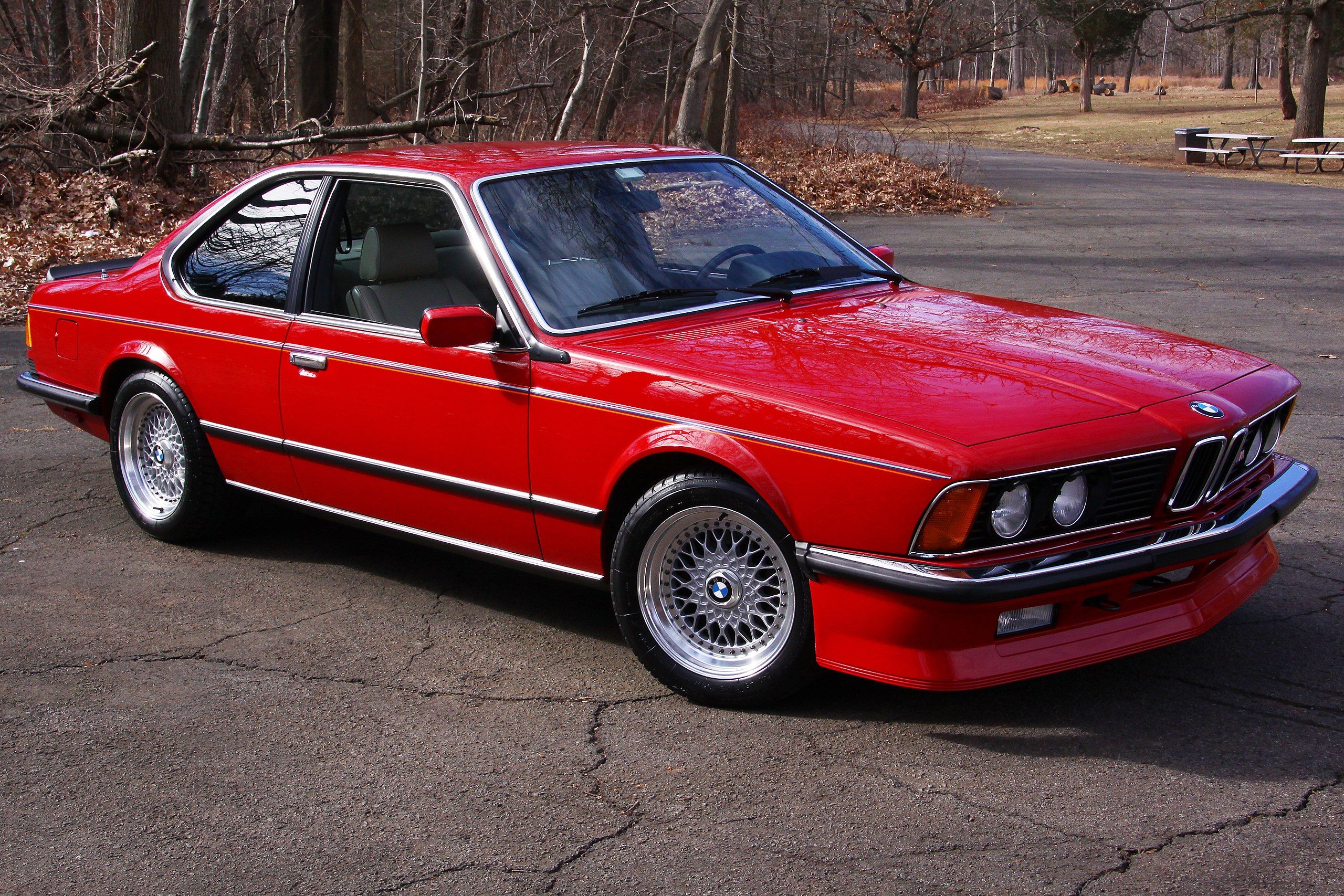 Red BMW 635CSi E24 parked on country road 