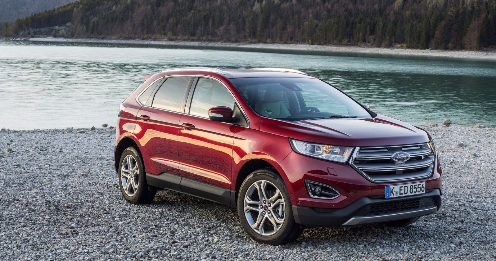 2018 Ford Edge in red besides a lake hd car view