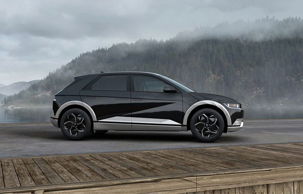 Black and silver 2023 Hyundai Ioniq-5 side view in front of a mountain lake