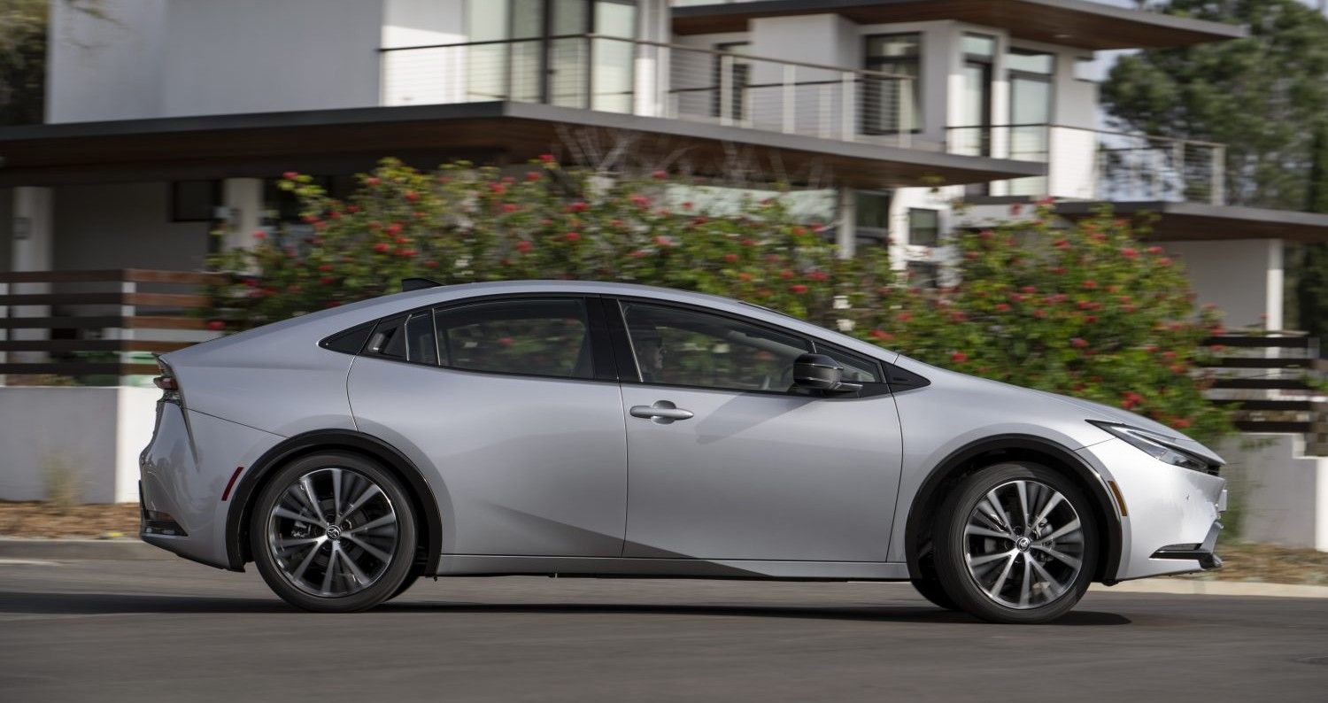 Toyota Prius Hybrid 2023 side view, dynamic street background, gray