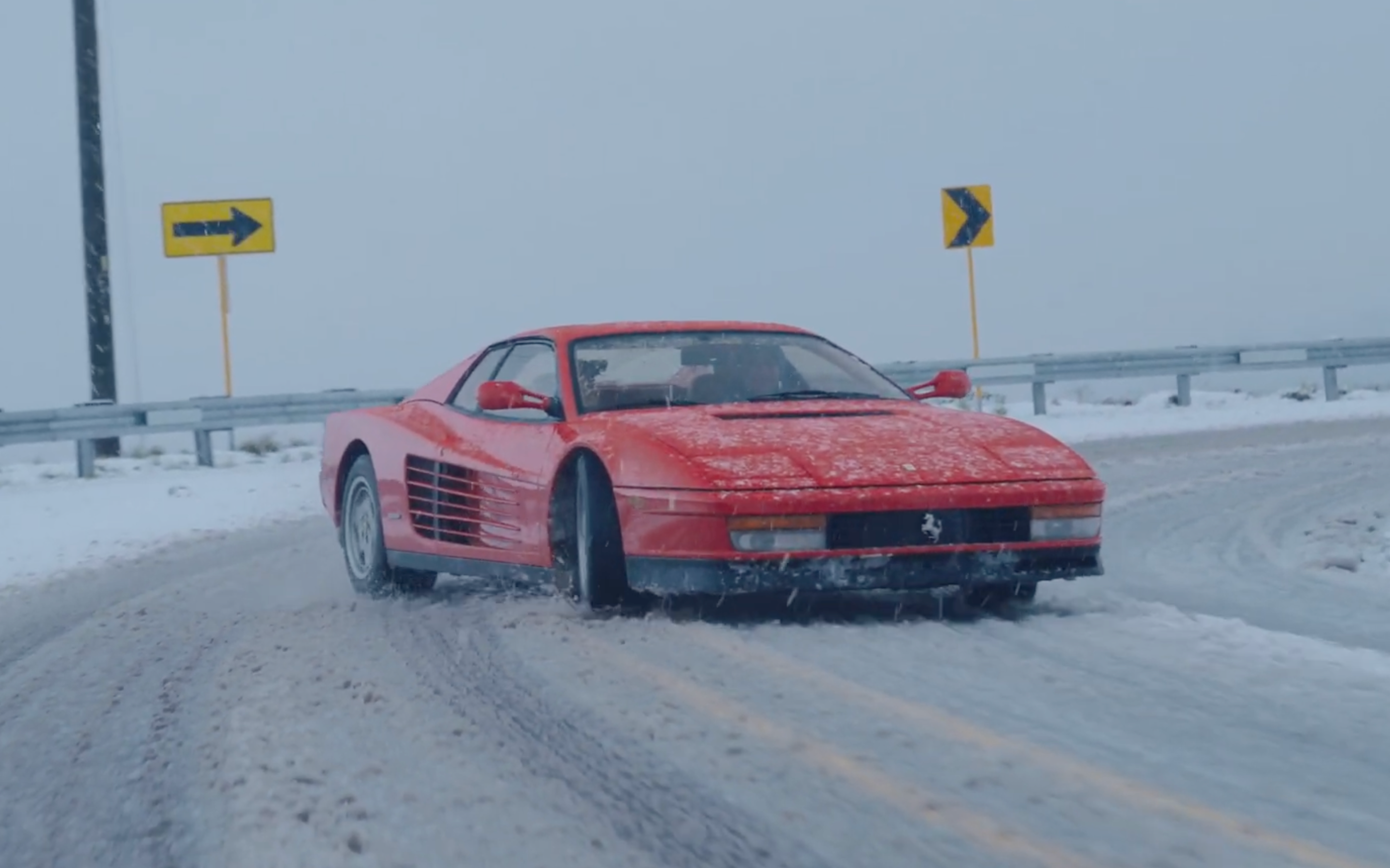 Coche deportivo rojo 1984 Ferrari Testarossa a la deriva en la nieve