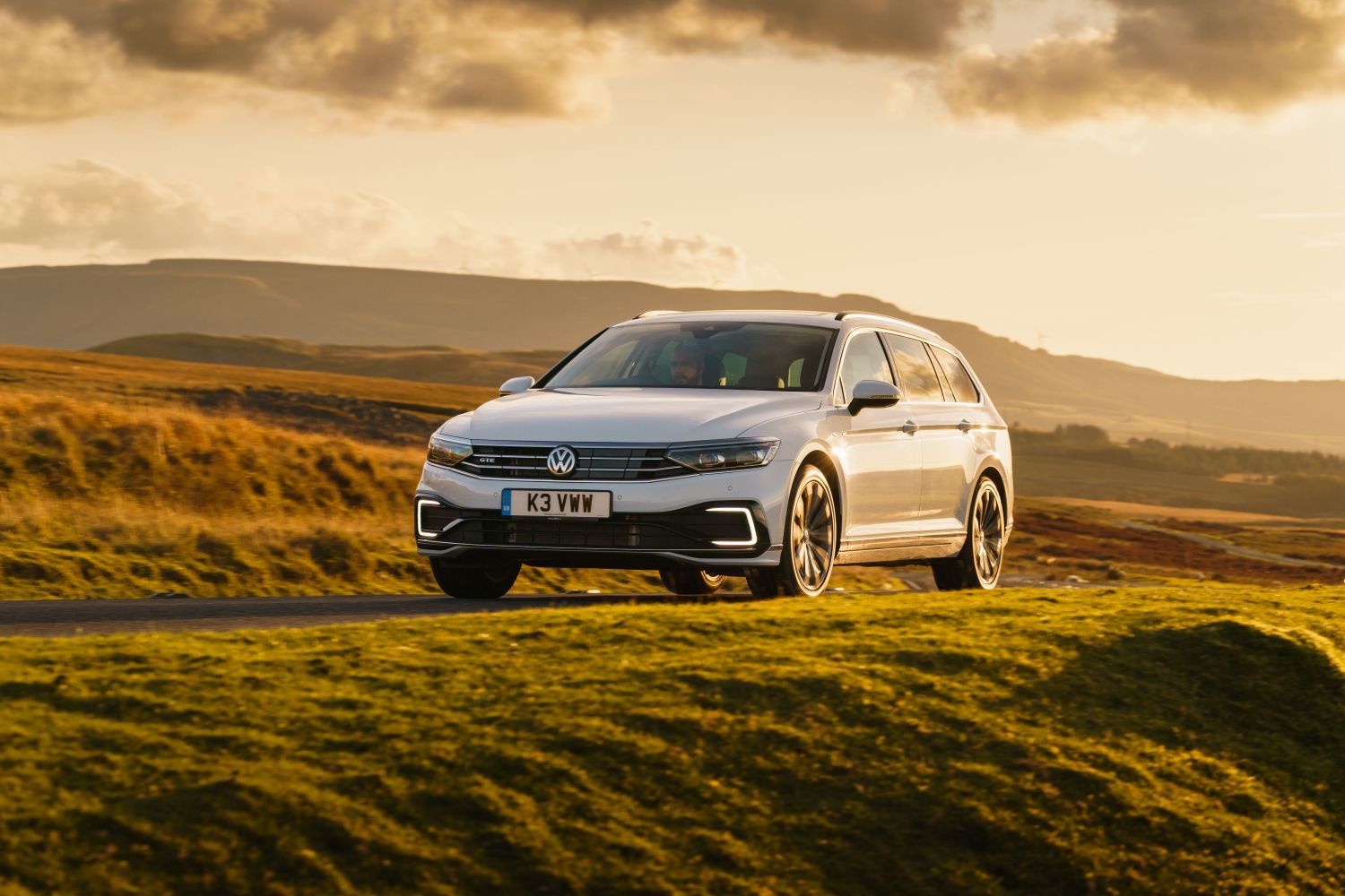 Volkswagen Passat GTE station wagon on country road during sunset