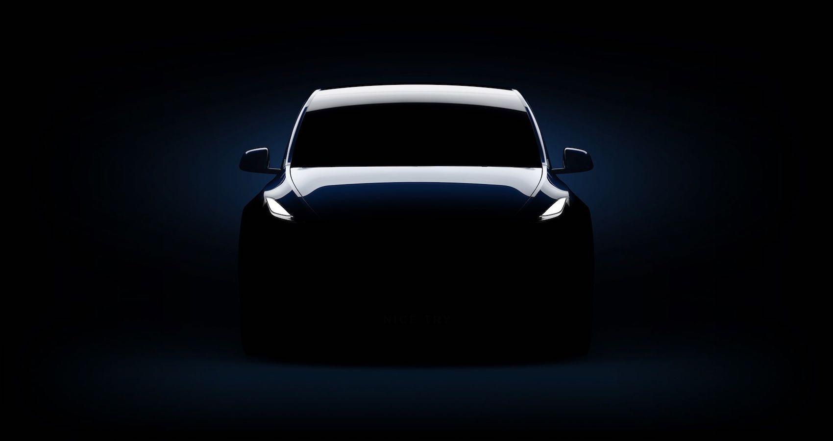 Tesla model y teaser front end in dark room 