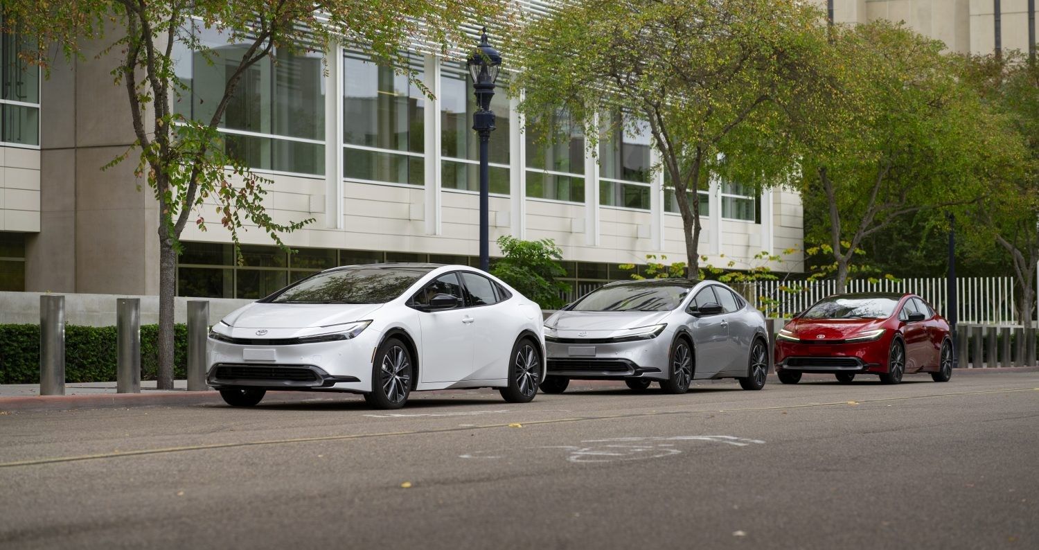 Three Prius 2023 cars parked in front of a building.