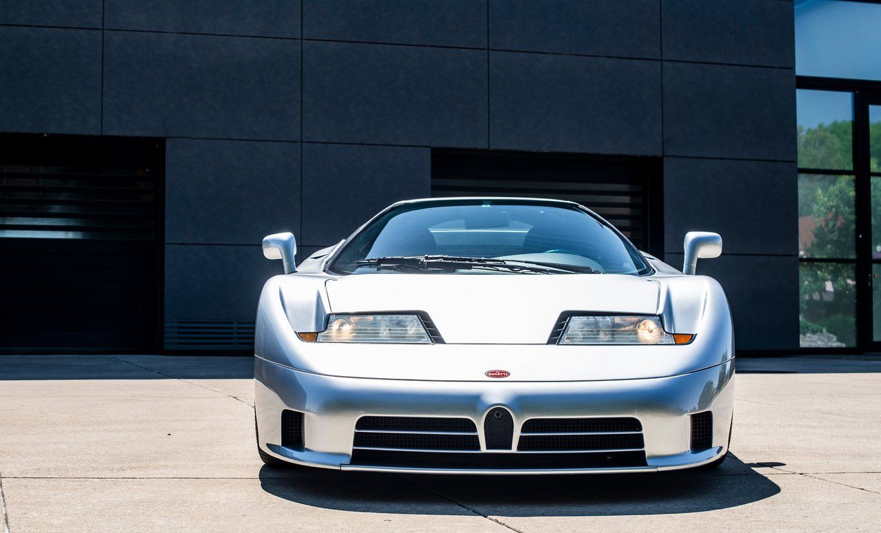 Silver Bugatti EB110 supercar parked