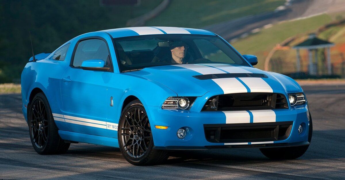 A blue 2013 Ford Mustang Shelby GT500 driving