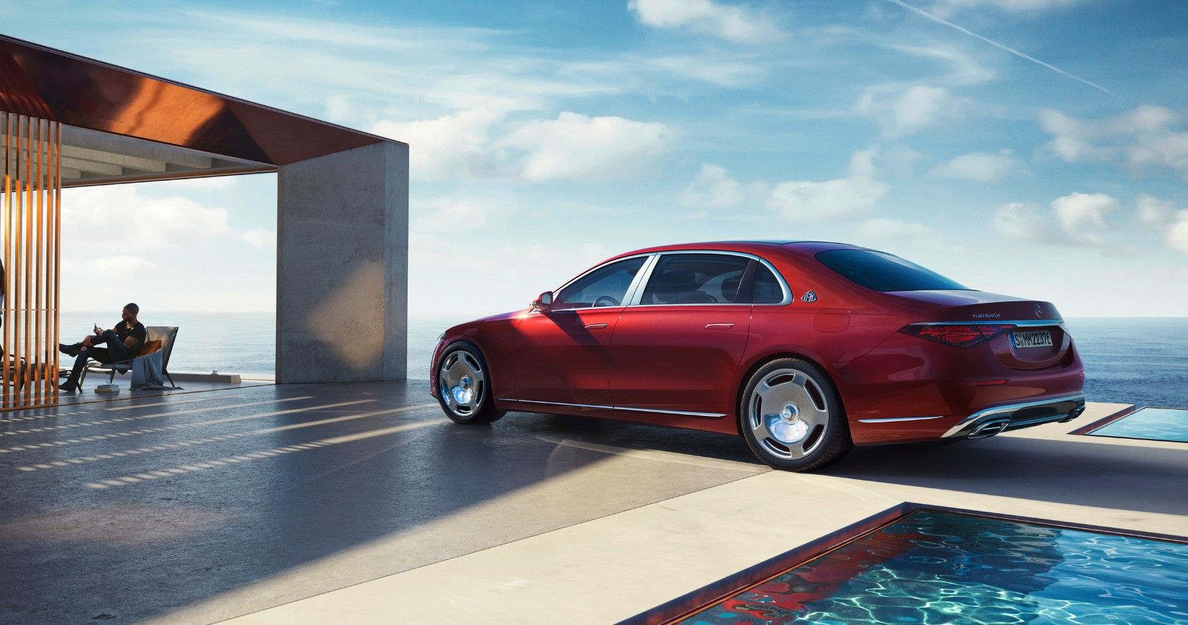 Red Mercedes-Mayback S 580 e parked by a pool