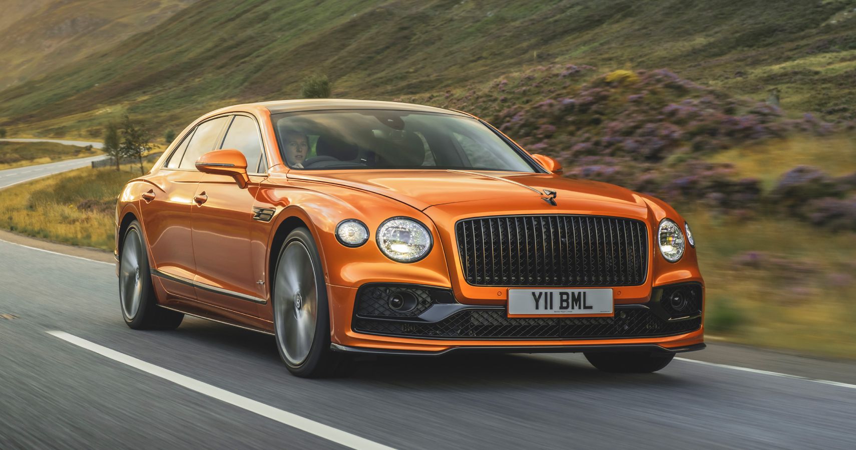 Orange Bentley Flying Spur Speed driven on the road