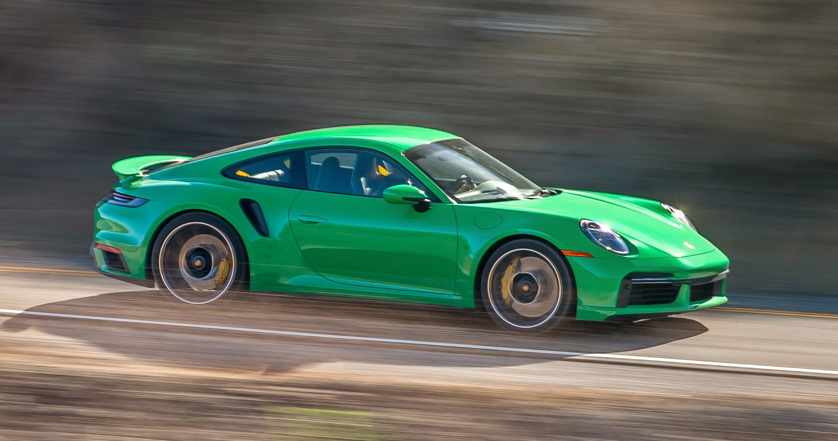 Green Porsche 911 Turbo S driven on the road