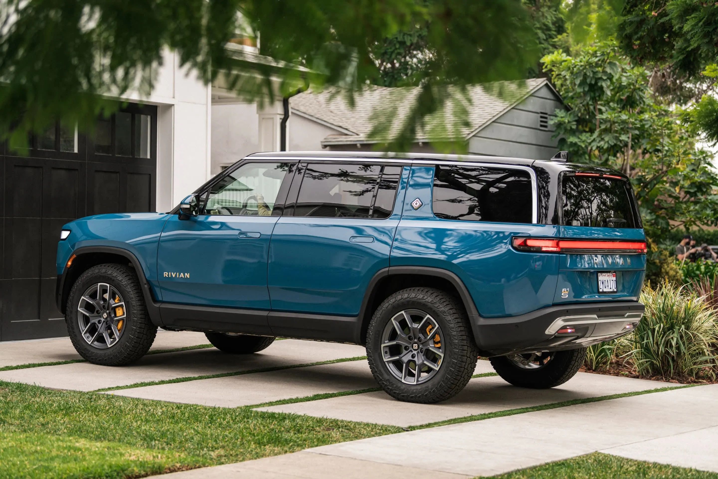 The 2023 Rivian R1S parked on a driveway. 