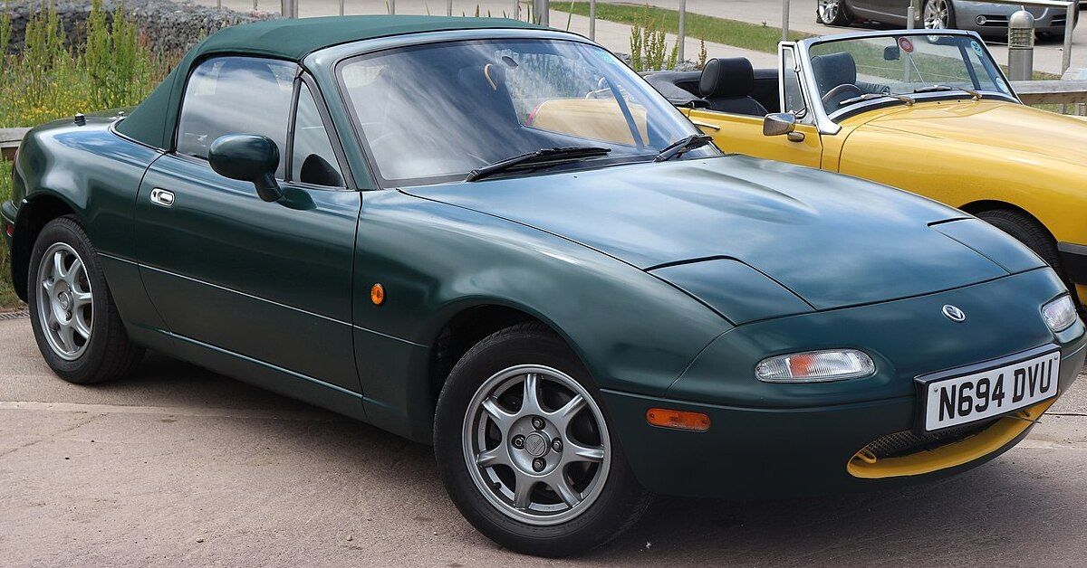 A green 1996 Mazda Eunos Roadster parked