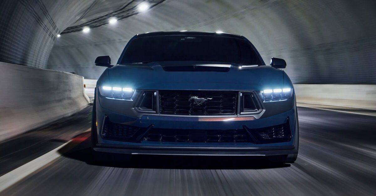 A blue 2024 Ford Mustang Dark Horse driving