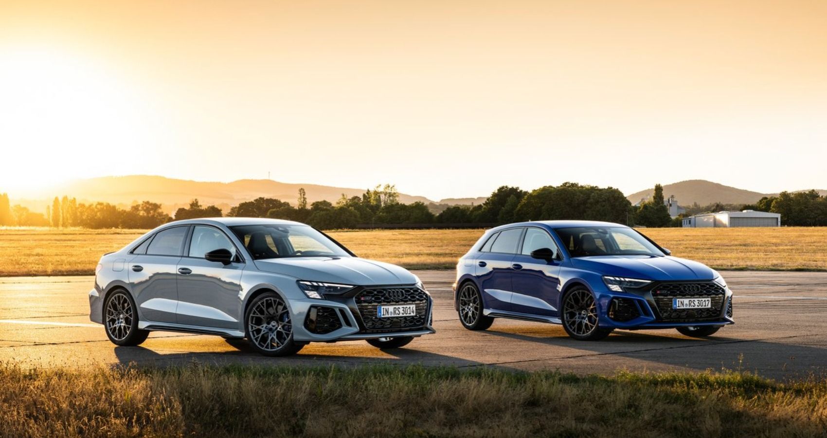 Изображение передней и правой сторон седана Audi RS3 2023 года выпуска и хот-хэтча